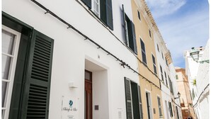 A narrow cobblestone street lined with traditional buildings, featuring a sign for 'Chic & Chic' on the first building. - Cheap & Chic Hotel (Ciutadella de Menorca)