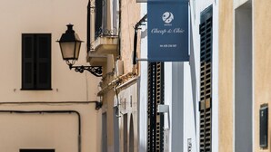 A narrow cobblestone street with a building featuring a sign for 'Cheep & Chic Hotels'. - Cheap & Chic Hotel (Ciutadella de Menorca)