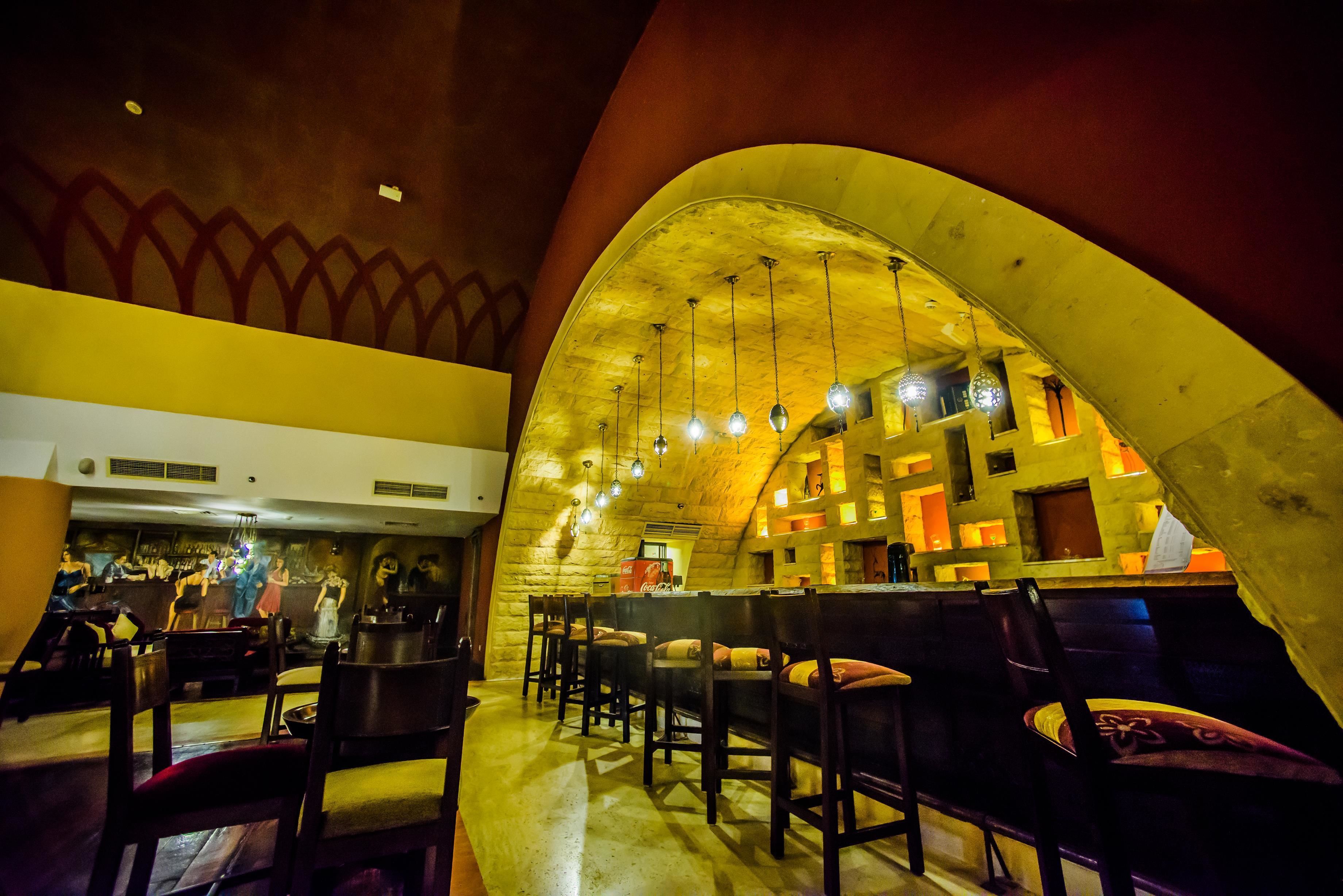 An interior with a vaulted ceiling, wooden chairs, and a bar area.