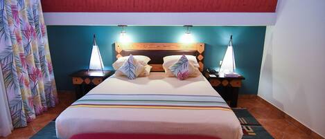 A bedroom with a large bed, two bedside tables, and a red ceiling.