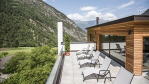 A terrace with outdoor seating and a mountain view. - Hotel Burgaunerhof (Martello)