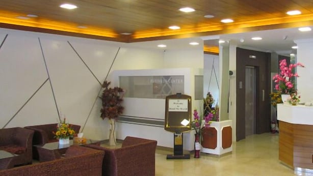 A hotel reception area with a reception desk, seating area, and a wall-mounted sign. - Hotel My World (Mandalay)