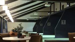 Um interior moderno com uma mesa redonda e cadeiras, um vaso de planta e uma escada com degraus numerados.