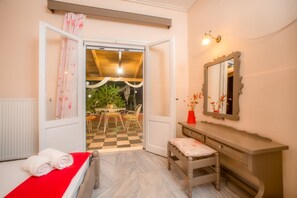 A bedroom with a bed, a bench, a vanity, and a mirror. - Babis Studios (Zakynthos)