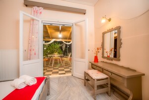 Un dormitorio con cama, un banco, un tocador y un espejo.