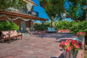 A patio with a wooden bench, a table, and potted plants. - Babis Studios (Zakynthos)