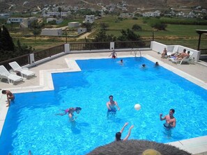 Una piscina al aire libre de temporada, sombrillas