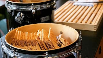 A kitchen with a black stove, a wooden cutting board, and a tray of bread.