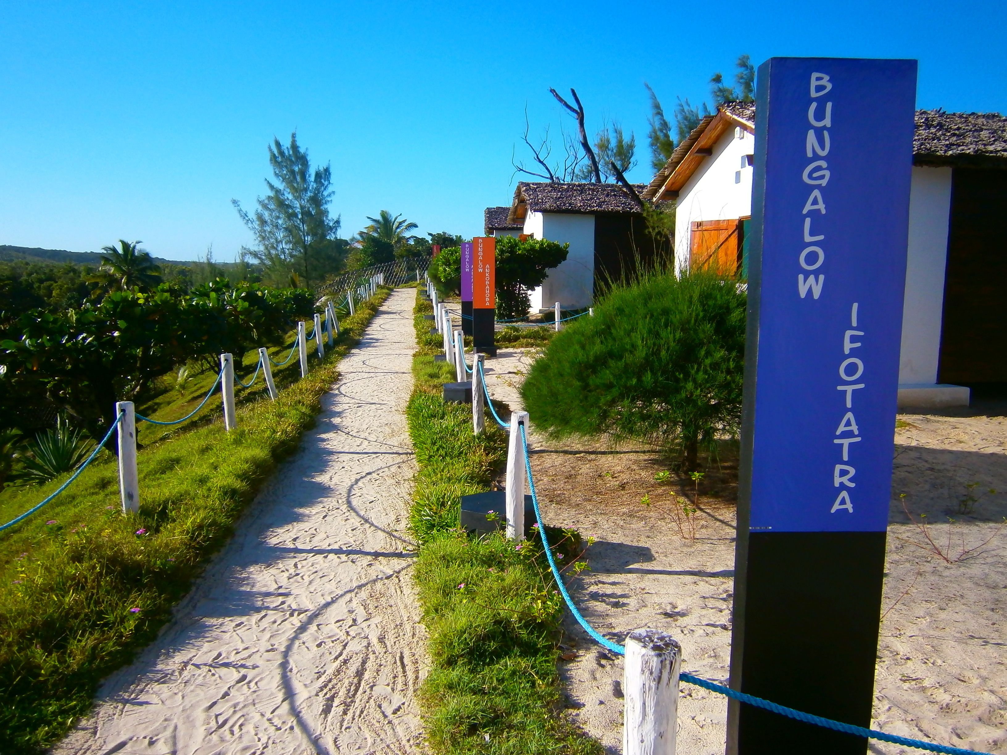 A pathway leading to a bungalow area with a sign reading "BUNGALOW I FOTATRA".