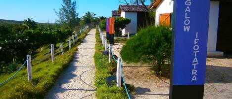 A pathway leading to a bungalow area with a sign reading "BUNGALOW I FOTATRA".
