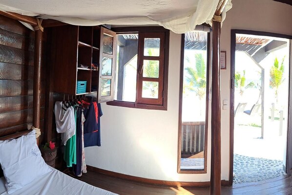 Una habitación con cama, armario, ventana y puerta que da al exterior.
