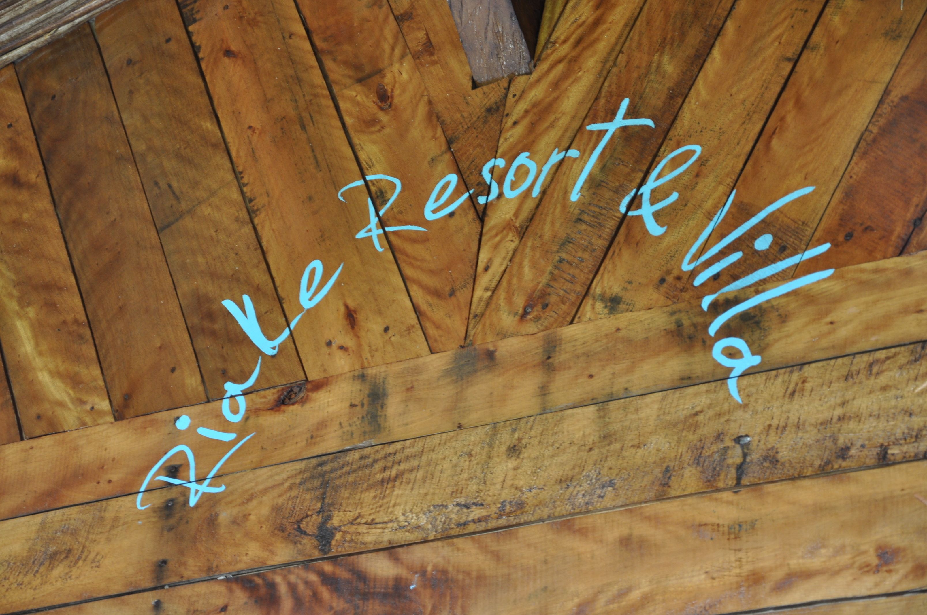A wooden ceiling with the text "Rialle Resort Villa" written on it.