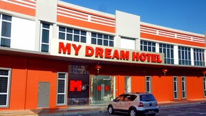 A hotel named "MY DREAM HOTEL" with a prominent sign, a car parked in front, and a clear blue sky in the background. - My Dream Hotel (Sandakan)