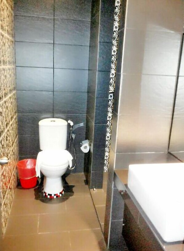 Um banheiro com vaso sanitário, chuveiro e banheira.