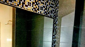 A bathroom with a white sink, a mirror, and a tiled backsplash. - My Dream Hotel (Sandakan)