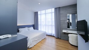 A modern hotel room with a large bed, a desk with a phone, a TV, and a large window with curtains. - My Dream Hotel (Sandakan)