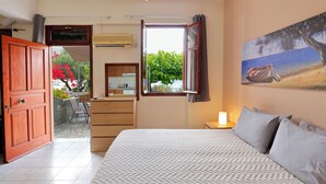 Un dormitorio con una cama grande, un ventanal con vistas a zonas verdes, un cuadro en la pared y una puerta de madera.