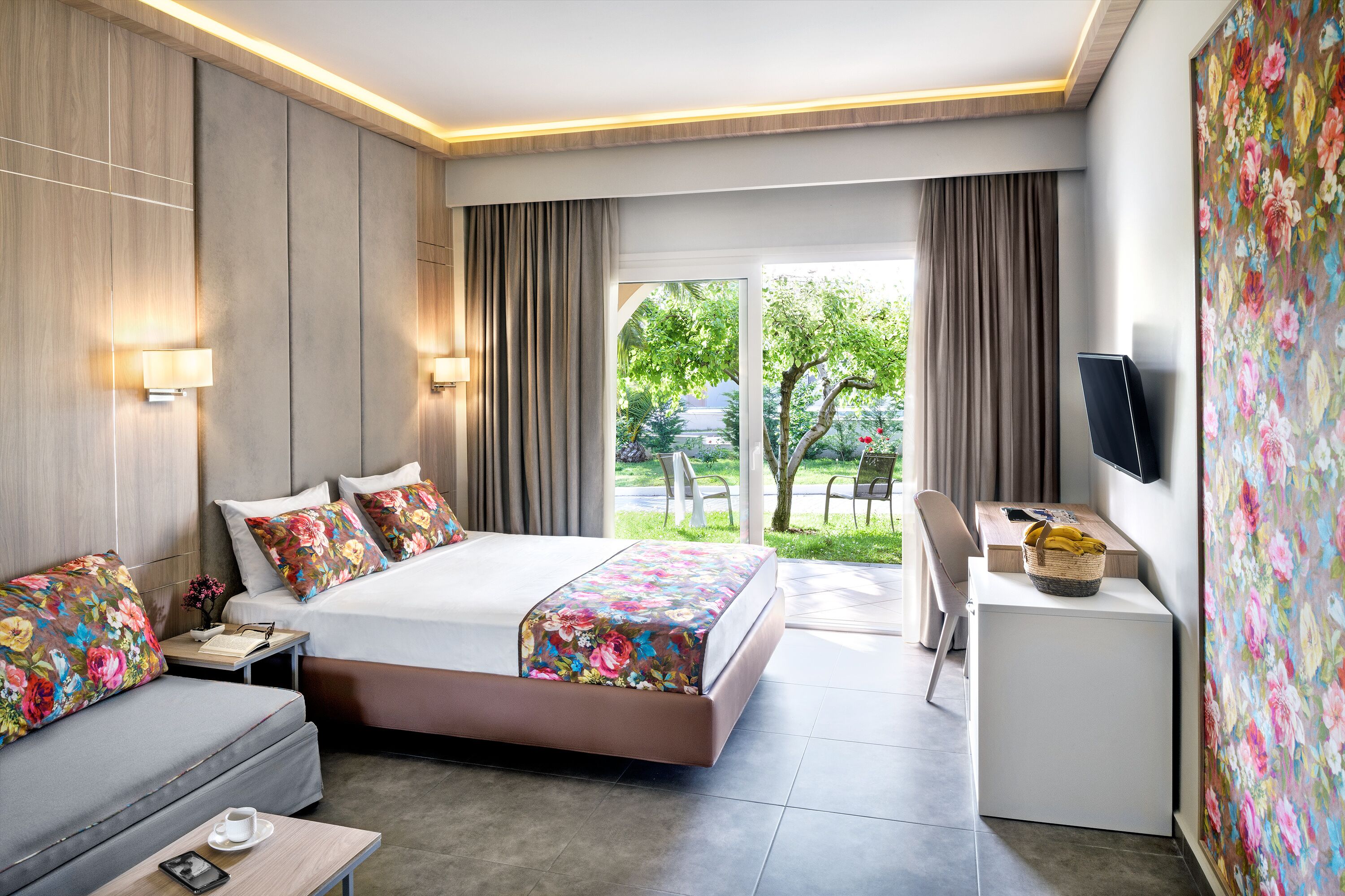 Una habitación de hotel con cama, sofá, escritorio y televisor.