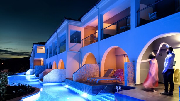 Un edificio moderno con area piscina, caratterizzato da un ambiente esterno ben illuminato e una scala che conduce a un livello superiore.