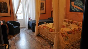 Un dormitorio con una cama con dosel, una silla, un escritorio y una ventana con cortinas.