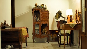 Una habitación con un armario de madera, un escritorio con una lámpara y una silla.