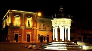 Un edificio de arquitectura clásica, con columnas y una cúpula, iluminado en la noche.