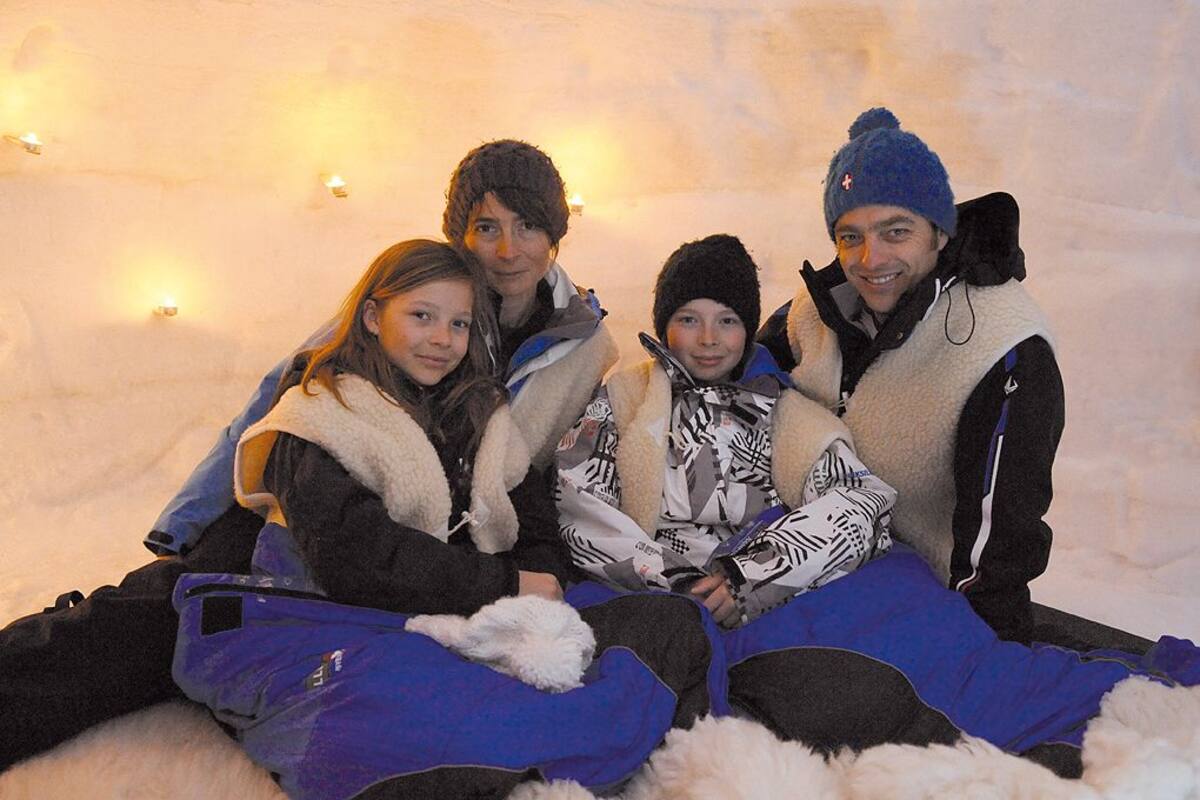 Un grupo de personas sentadas sobre la nieve.