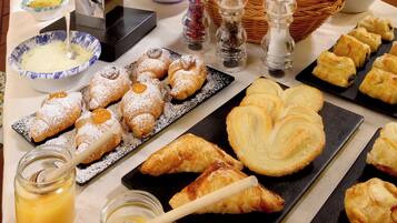 Ein reichhaltiges Buffet mit Gebäck, Früchten und Getränken.