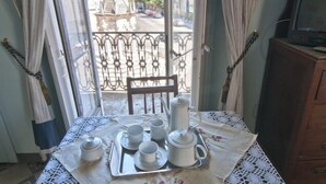 A table set with white teacups, saucers, a teapot, and a tray, with lace tablecloth and curtains. - Angeli dell'Osanna B&B (Nardò)