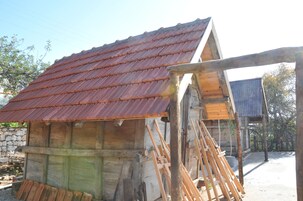 Un edificio de madera con techo de metal corrugado y estructura de madera al frente.