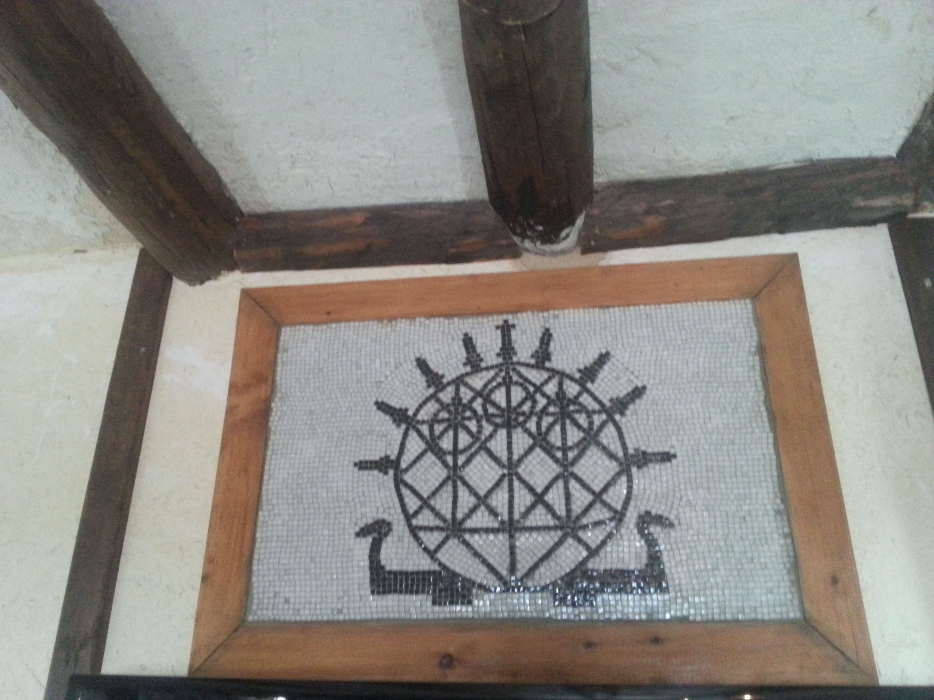 Un mosaico enmarco con diseños geométricos y una rosa de los vientos.