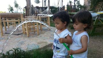 Children can play and relax in the outdoor play area with a hammock and table.