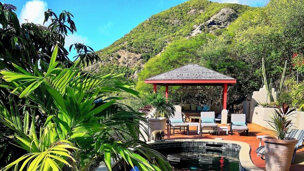 A pool area with lounge chairs, a gazebo, and a view of a mountainous landscape. - Arca Villa and B&B (Falmouth Harbour)