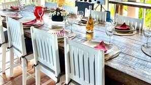 An outdoor dining area with a wooden table set for six, a grill, and a scenic mountain view. - Arca Villa and B&B (Falmouth Harbour)