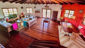 A spacious living area with a high ceiling, wooden flooring, and a cozy seating arrangement. - Arca Villa and B&B (Falmouth Harbour)