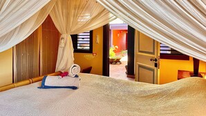 An attic bedroom with a canopy bed, a view of the outside, and a small balcony. - Arca Villa and B&B (Falmouth Harbour)