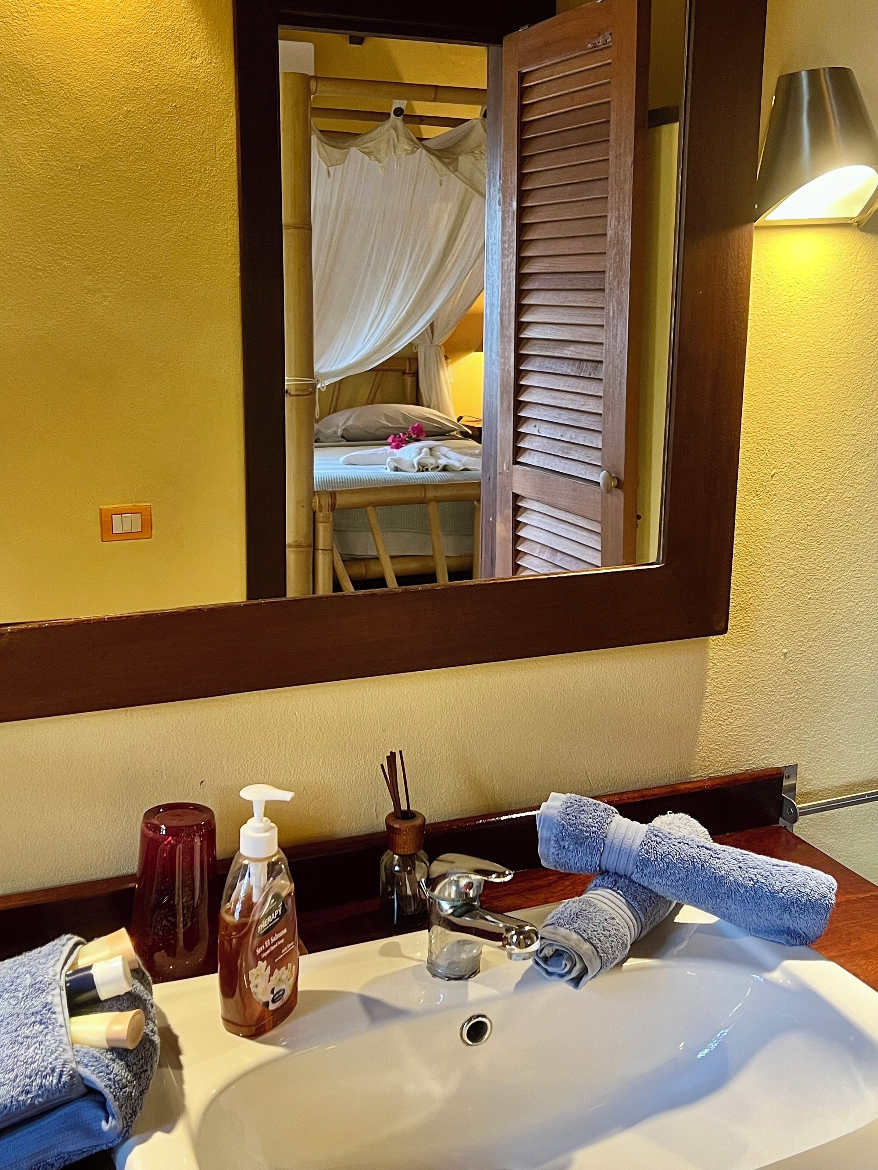 Ein Hotelbad mit Waschbecken, Spiegel und Pflegeprodukten.