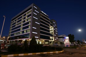 A multi-story hotel with illuminated windows and a prominent sign.