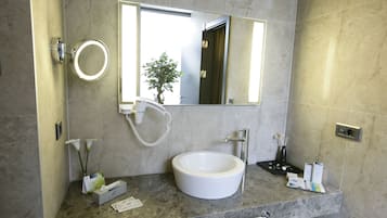A bathroom with a round mirror, a sink, and a towel rack.
