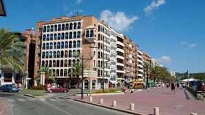 Un hotel de varios pisos con balcones y un paseo peatonal.
