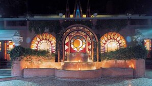 A courtyard with a central fountain, surrounded by brick walls and illuminated by decorative lighting. - Hotel Il Quadrifoglio (Rome)