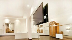 A modern bathroom with a large mirror, a bathtub, and a vanity with a sink. - Hotel Il Quadrifoglio (Rome)