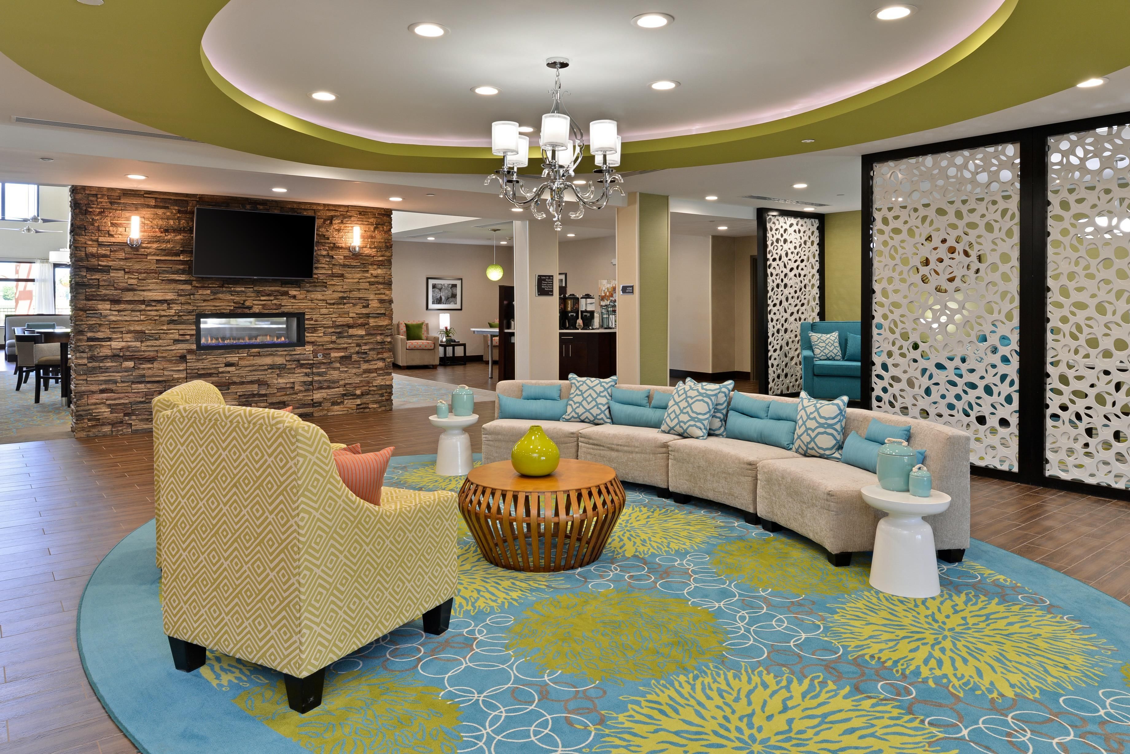 A modern lobby with a curved sofa, a round coffee table, and a stone accent wall.