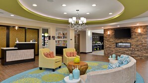 A hotel lobby with a reception desk, seating area, and a fireplace. - Homewood Suites Houma, La (Houma)