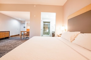 Una habitación de hotel con una cama grande, un escritorio y una silla.