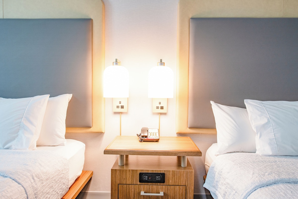 Luxe beddengoed, een kluis op de kamer, een bureau, een laptopwerkplek