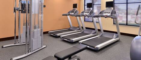A gym with treadmills, a weight machine, and a stationary bike.