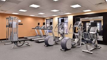 A gym with treadmills, elliptical machines, and weightlifting equipment.
