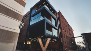Un edificio moderno con una entrada en forma de V destacada y amplios ventanales de vidrio.