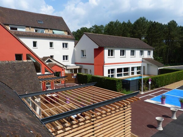 Zona residencial con piscina, un área de estar techada al aire libre y un edificio en construcción.